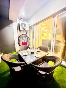 a table and chairs on a room with a window at LMY Boutique Hotel Serviced Apartments Blue Area Islamabad in Islamabad