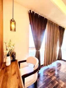 a living room with a white chair and a window at LMY Boutique Hotel Serviced Apartments Blue Area Islamabad in Islamabad