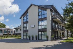 a large white building with glass windows and stairs at 2rest in Palanga