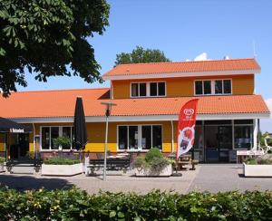 a yellow building with an umbrella and benches in front of it at Chalet nr 43 in Molkwerum