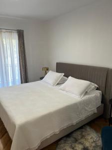 a bed with white sheets and pillows in a bedroom at Agata in Šibenik