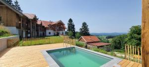 a swimming pool on a deck with a house at Bergmichlhof in Ragnitz