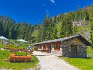 a small building with a bench in front of it at Malga Valmaggiore in Bellamonte +25 photos