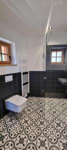 a bathroom with a toilet and a shower and a tile floor at Bergmichlhof in Ragnitz +8 photos