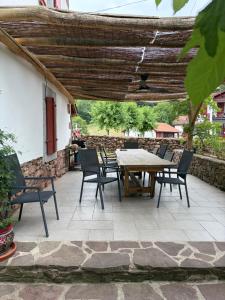 a patio with a wooden table and chairs at chambres d'hôtes Etche Iza in Hosta