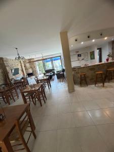 a restaurant with wooden tables and chairs and a bar at Esperando in Maroni
