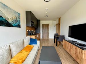a living room with a couch and a flat screen tv at Apartmán Valašský Eden in Horní Bečva