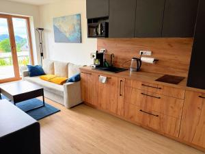 a living room with a couch and a kitchen at Apartmán Valašský Eden in Horní Bečva