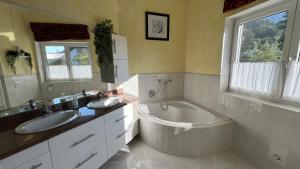 a bathroom with two sinks and a tub and a toilet at LH Rooms in Absam