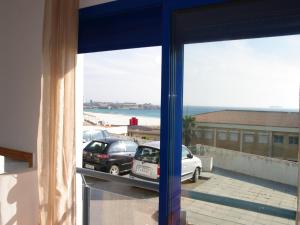 una ventana con vistas a un coche aparcado en un aparcamiento en Livingtarifa Apartamento Blue I, en Tarifa