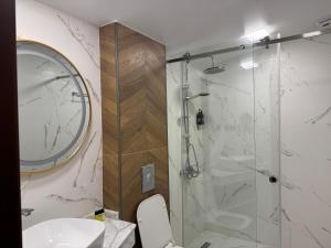 a bathroom with a shower and a toilet and a sink at Magnetiti Hotel in Ureki +161 photos