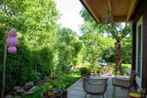 a patio with two chairs and a table with plants at B&B Le Maitre in Renkum