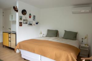 a bedroom with a large bed and a white wall at B&B Le Maitre in Renkum