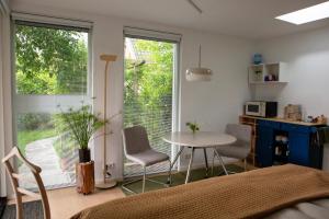 a room with a table and chairs and a kitchen at B&B Le Maitre in Renkum