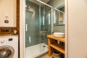 a bathroom with a sink and a washing machine at L'Igloo - Balcon- Vue- Chic pres St-Lary in Vignec