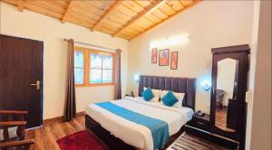 a bedroom with a large bed with blue pillows at The Woods Boho in Nainital