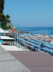 a beach with lots of chairs and umbrellas at A cà du Piero in Albisola Superiore