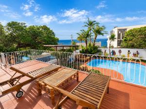a balcony with a picnic table and a swimming pool at SeaViu Camps Bay in Cape Town