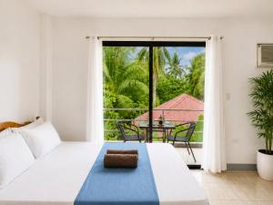 a bedroom with a bed and a table and a large window at Yayay Siargao - Generator & Starlink in General Luna +81 photos