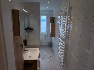 a bathroom with a sink and a shower with a window at Tom s Apartment II in Knittelfeld +14 photos