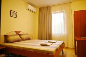 a bedroom with a bed with two towels on it at Zlatna Ribka in Chernomorets