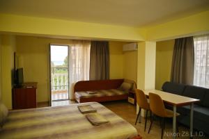 a hotel room with a bed and a couch and a table at Zlatna Ribka in Chernomorets