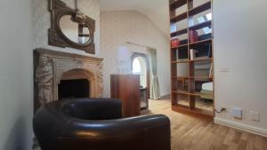 a living room with a leather chair and a fireplace at Hotel Villa Fanti in Loreto