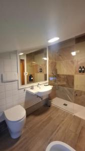 a bathroom with a toilet and a sink and a shower at Hotel Villa Fanti in Loreto