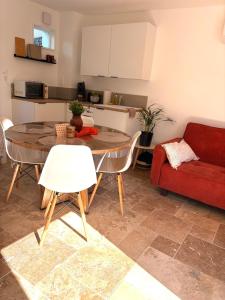 a living room with a table and a red couch at Cottage cosy avec terrasse 5pers proche Etretat in Bolbec +21 photos
