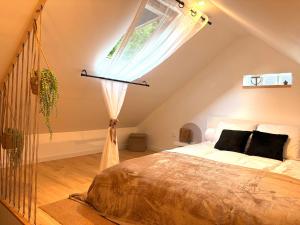 a bedroom with a large bed with a window at Cottage cosy avec terrasse 5pers proche Etretat in Bolbec