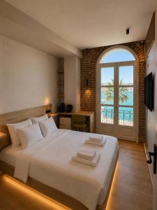 a bedroom with a large bed with a large window at Neossiko Chios in Chios