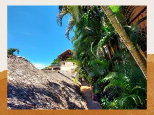 a group of palm trees next to a building at Hotel Les Boucaniers in Ambatoloaka