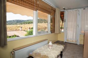 a dining room with a table and two windows at Foothills loft in Keratea