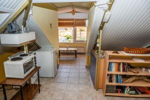 a room with a staircase and a kitchen with a microwave at Foothills loft in Keratea
