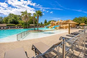 a pool at a resort with chairs and a water park at Camping Oléron Cap Soleil MH Climatisé in Saint-Denis-dʼOléron
