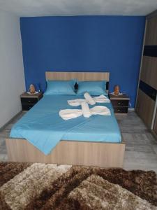 a blue bed with two white towels on it at Casa Micu in Corbu