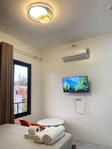 a bedroom with a bed and a table and a window at AMV Hotel, Events Place & Restaurant in Mamburao
