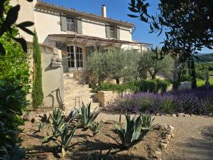 an old house with a garden in front of it at Mas Cerisiers in Saint-Martin-de-Castillon