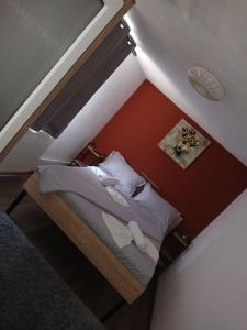 a small bed in a room with red walls at Casa Micu in Corbu