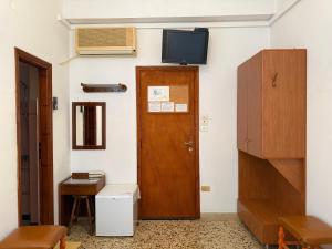 a room with a door and a television on the wall at Kythereia Hotel in Agia Pelagia