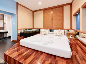 a large white bed in a room with wooden floors at Suan Palm Garden View in Rayong +22 photos