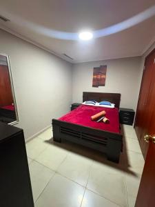 a bedroom with a bed with a red blanket at Departamento 68 river 2 in Guayaquil +28 photos