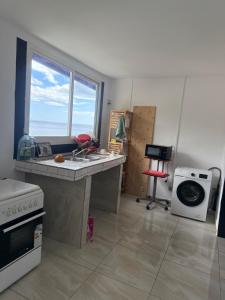 a kitchen with a sink and a counter with a window at Résidence Maeva in Mtsamboro