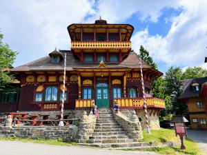 a large wooden house with people standing in front of it at Apartmán Valašský Eden in Horní Bečva