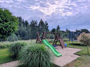 a playground with a green slide in a park at Sub Silva in Bałtów +21 photos