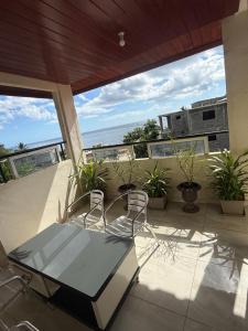 two chairs and a table on a balcony with the ocean at Résidence Maeva in Mtsamboro