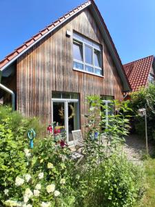 a wooden house with a garden in front of it at hej atelier Ferienwohnung in Heiligenthal