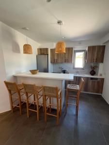 a kitchen with a island with chairs and a counter at Maison Blanche in Vóthon