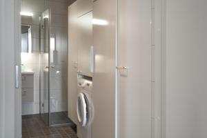 a white bathroom with a washer and dryer in it at Ski-Inn Huoneisto in Vuokatti +42 photos