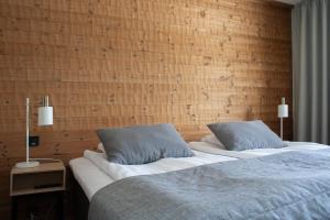 a bedroom with two beds and a brick wall at Ski-Inn Huoneisto in Vuokatti